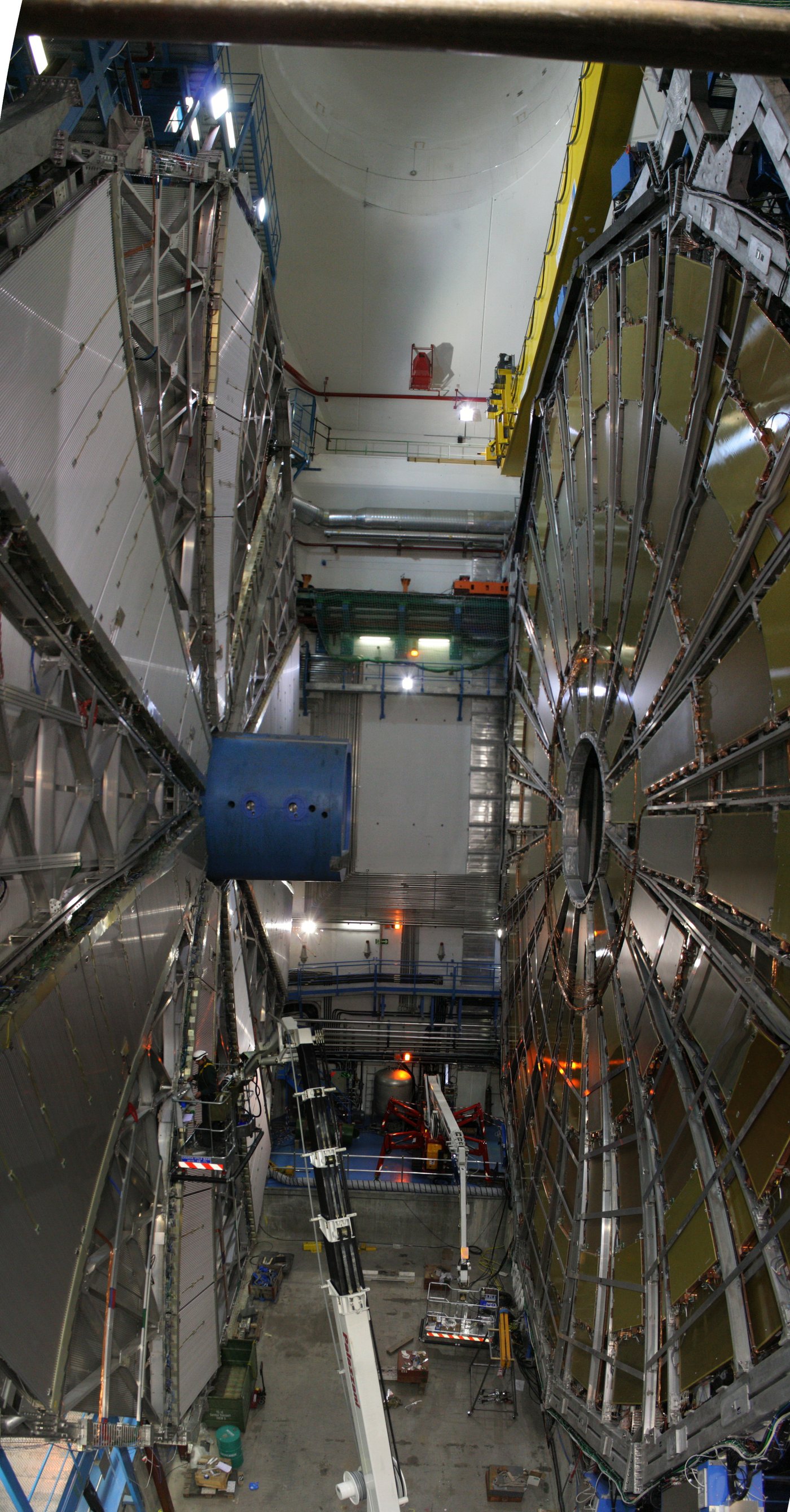 Historical photograph looking down into the ATLAS detector cavern at CERN during its construction, showing the detector's large wheel-shaped toroid magnet structures.