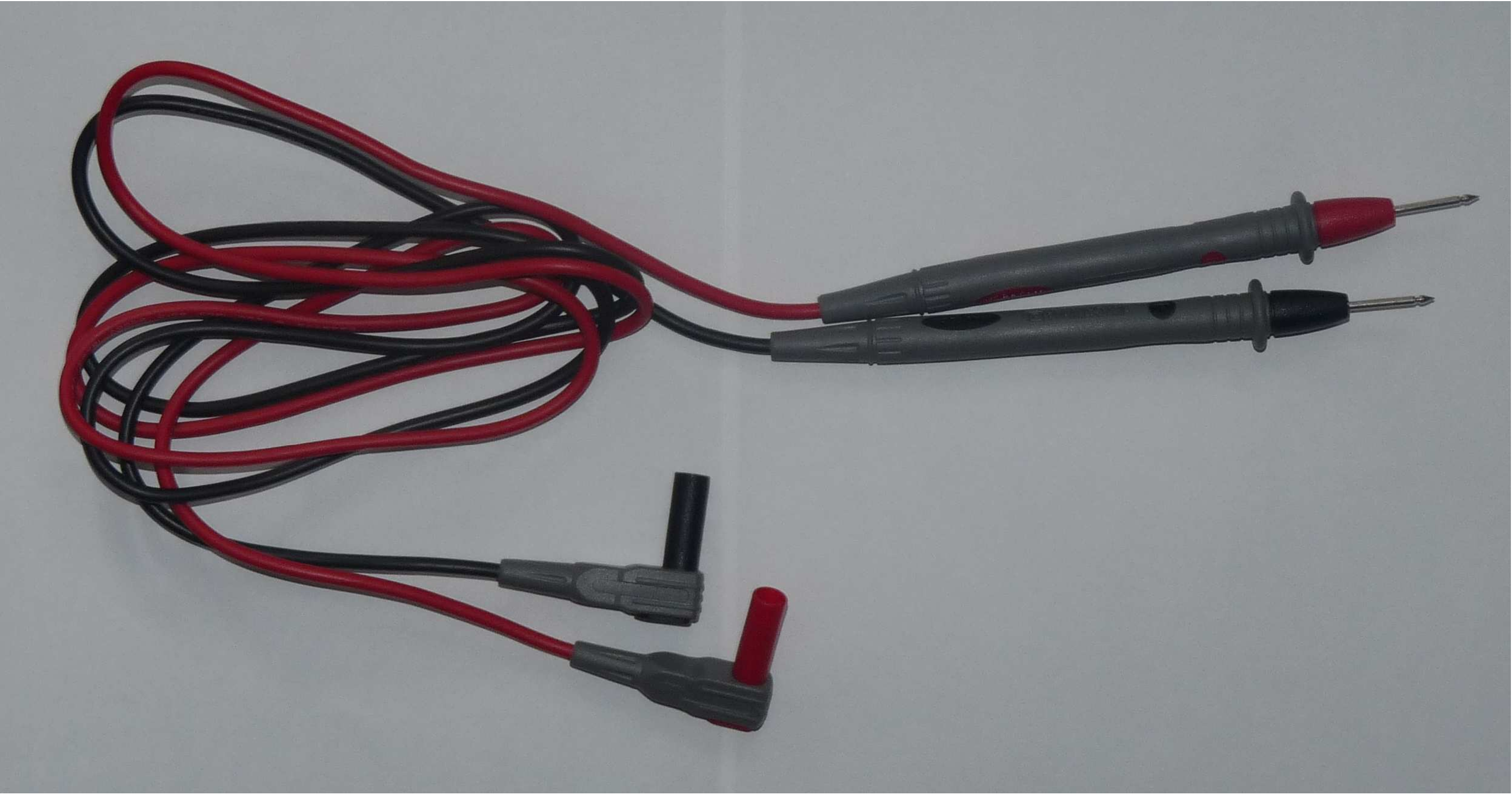 Image of a set of electrical test leads. Each lead is comprised of a connector that fits the voltmeter and a tubular section with a pointed metal tip. The connector and metal probe tip are connected by wire. One lead is red and one is black.