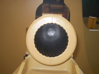 A close-up view looking down the rifled barrel of a large artillery piece or cannon, showcasing the distinct spiral grooves inside its muzzle.