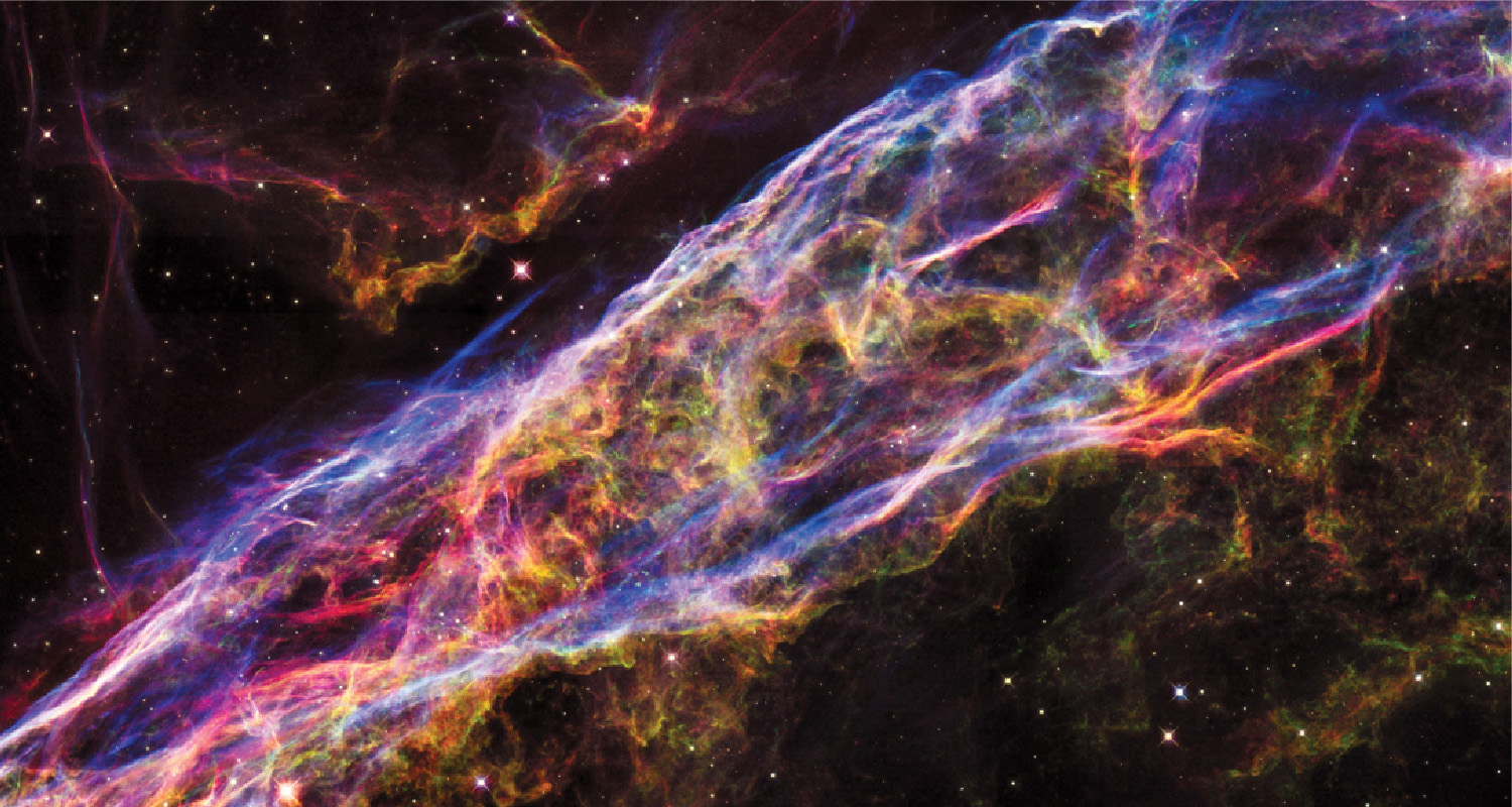 A filament of gas resembles an enormous bubble or surface stretching across the entire image. Stars and smaller gas filaments are also visible in the background.