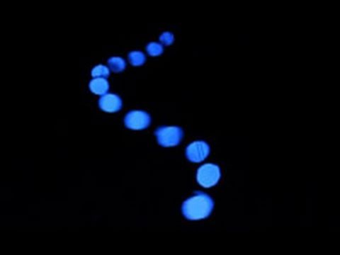 A row of pendulums with progressively changing lengths forms a wave-like pattern.