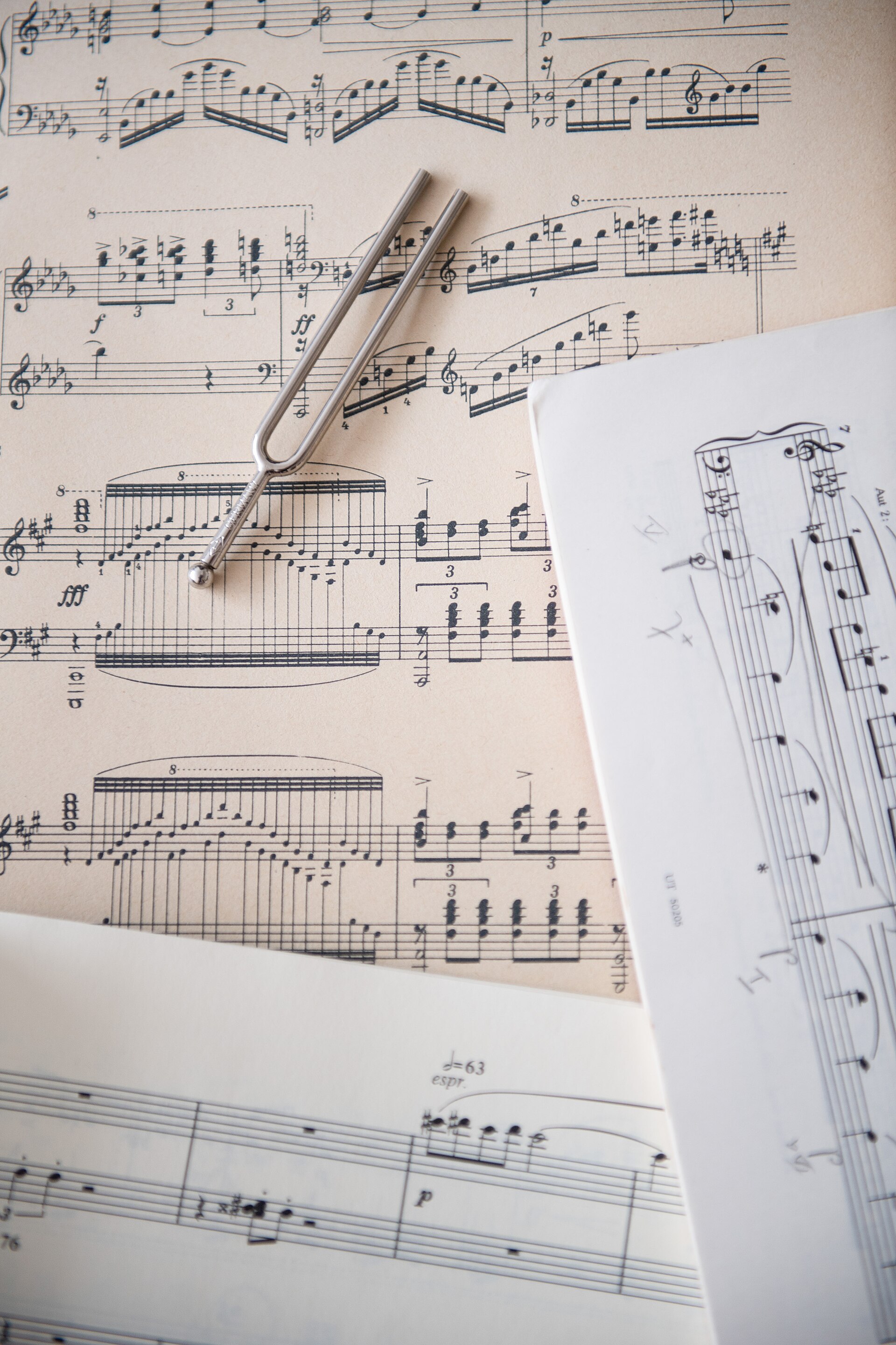 A tuning fork resting on a page of sheet music.