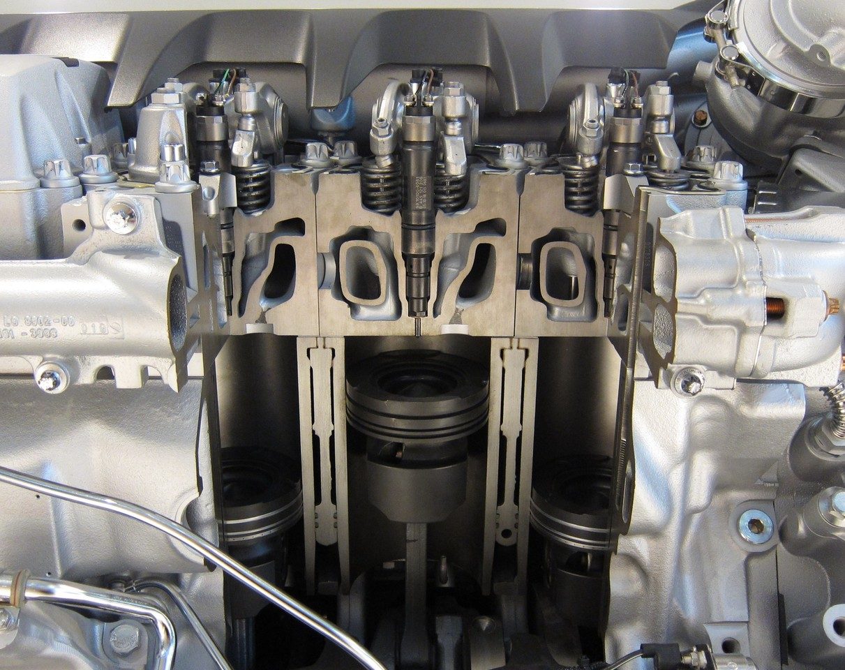 A cutaway in a truck engine reveals three pistons in their cylinders. A closed system is a useful tool for studying the air trapped in a cylinder. The photographed engine is a diesel V8 from man.