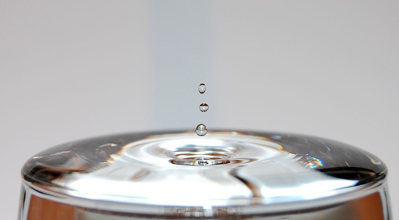 Surface tension gives liquids fascinating visual properties but has no consequence in thermodynamics. For us, it is the “same water” whether in the gaseous or liquid state.