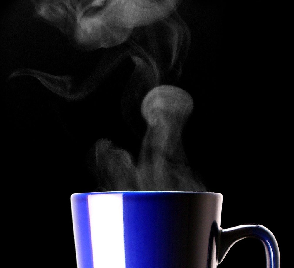 The visible water above a container of hot liquid, sometimes called “steam”, is in the liquid state and not gaseous. These droplets are observable to the naked eye.